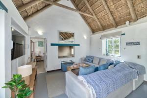 a living room with a couch and a table at Cape Creek Cottage, Luxury Coastal Getaway in Struisbaai