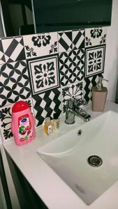a bathroom sink with a pink toaster on top of it at Au Nid Douillet in Gilocourt