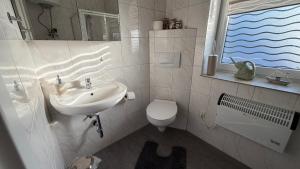 a bathroom with a sink and a toilet at Bitterfeld Apartment modern & gemütlich in Holzweißig