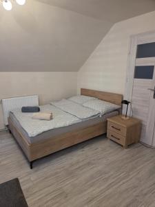 a bedroom with a large bed and a night stand at Baza wypadowa 4 in Lubań