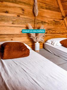 a bedroom with two beds and a sign on the wall at Hostel Costa Terral in Matinhos