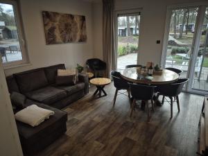 a living room with a couch and a table at Casa Sallandia met Outdoor Wellness! in Haarle