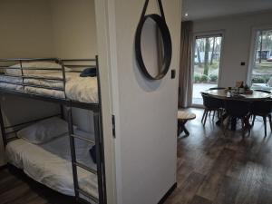 a room with two bunk beds and a dining room at Casa Sallandia met Outdoor Wellness! in Haarle