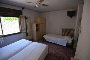 a bedroom with two beds and a ceiling fan at Hotel Alla Noce in Limone sul Garda +20 photos