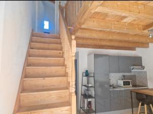 a wooden staircase in a room with a kitchen at Les Chênes Verts in Corte +8 photos