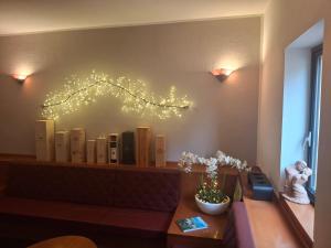 a shelf with books and a branch on the wall at Hotel Agnello in Taino