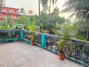a balcony with a blue fence and palm trees at Virens Heaven Stays in Calangute