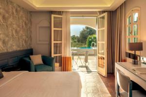 a bedroom with a bed and a view of a patio at Zeus Eretria Resort in Eretria