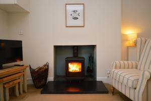 a living room with a fireplace and a tv at Seascape in Kames
