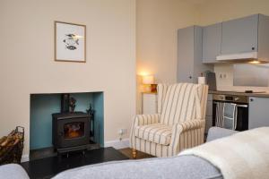 a living room with a chair and a stove at Seascape in Kames