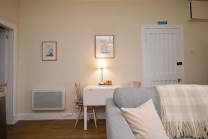 a living room with a couch and a table with a lamp at Seascape in Kames