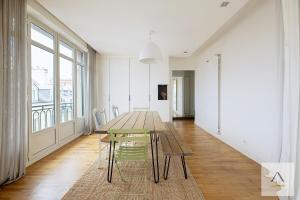 a dining room with a wooden table and chairs at Le Palais du Commerce in Rennes +15 photos