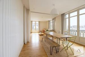 a dining room with a table and some windows at Le Palais du Commerce in Rennes