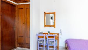 a bedroom with a table and two chairs and a mirror at Blue Sky in Palaiochora