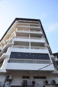 a tall white building with a lot of windows at Om Shiv Hotel Formerly The Treat Hotel in Madgaon
