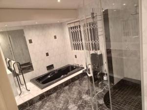 a bathroom with a sink and a shower at Orchids Lodge in Fourways +26 photos