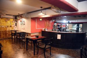 a restaurant with tables and chairs and a bar at Om Shiv Hotel Formerly The Treat Hotel in Madgaon
