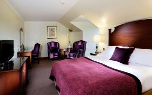 a hotel room with a bed and a desk and chairs at Macdonald Inchyra Hotel & Spa in Falkirk