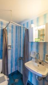 a blue tiled bathroom with a sink and a shower at Blue Sky in Palaiochora +32 photos