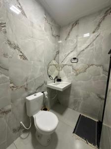 ein Badezimmer mit weißer Toilette und Waschbecken in der Unterkunft DeckMC in Itarema + 10 Fotos