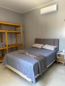 ein Schlafzimmer mit einem Bett mit einer blauen Decke in der Unterkunft DeckMC in Itarema