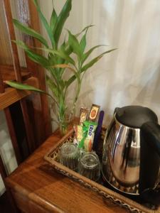 a table with a tea kettle and a plant on it at Colonial House Mekong River View in Luang Prabang