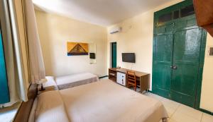 a room with two beds and a green door at Pousada Colonial Chile in Salvador