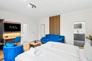 a hotel room with two beds and blue chairs at Mivano Apartments - Allergarten in Celle