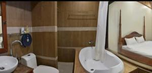 a bathroom with a sink and a toilet and a mirror at Colonial House Mekong River View in Luang Prabang
