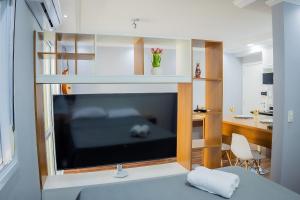a living room with a large flat screen tv at 1506 - studio novo e completo in Guarulhos