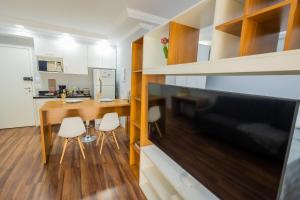 a kitchen and dining room with a television and a table at 1506 - studio novo e completo in Guarulhos