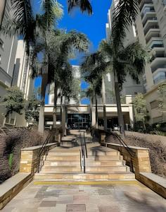 a set of stairs in front of a building with palm trees at 1506 - studio novo e completo in Guarulhos