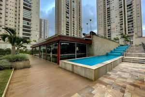 a building with a swimming pool next to tall buildings at 1506 - studio novo e completo in Guarulhos
