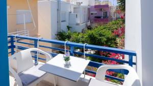 a table and chairs on a balcony with flowers at Blue Sky in Palaiochora