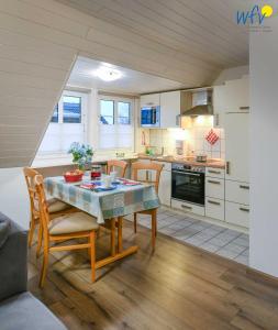 a kitchen and dining room with a table and chairs at Godenhus Ferienwohnung Mathis in Langeoog +17 photos