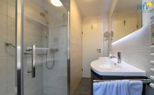 a bathroom with a sink and a shower at Godenhus Ferienwohnung Mathis in Langeoog
