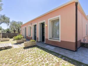 a pink house with a yard in front of it at Apartment Borgoverde-5 by Interhome in Imperia