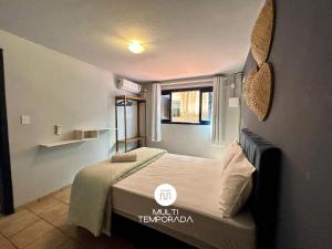 a small bedroom with a bed and a window at Canto das Praias - Florianópolis/SC in Florianópolis