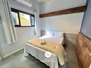 a bedroom with a bed with two slippers on it at Canto das Praias - Florianópolis/SC in Florianópolis