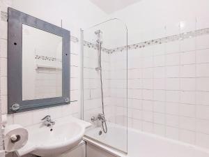 a white bathroom with a sink and a mirror at Studio Les Olympiades-28 by Interhome in Val Thorens +15 photos