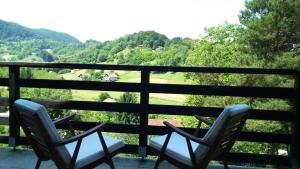 two chairs on a balcony looking out at the mountains at Kuća za odmor Trnac in Tuhelj