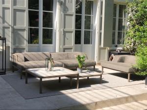 a couch and a coffee table on a patio at Les Jardins du Panthéon in Paris +38 photos