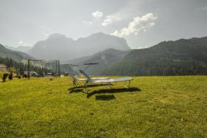 a bench in a field with mountains in the background at Apartments Rit in La Valle