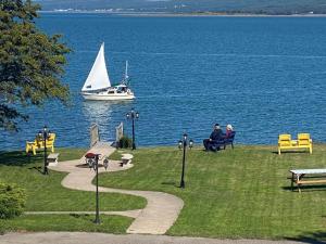 a sail boat in the water with people sitting on benches at Seawinds Motel & Suites in Digby