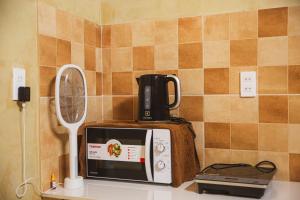 a kitchen counter with a coffee maker and a microwave at Ruby's Home- Doc Let's House in Ngân Hà