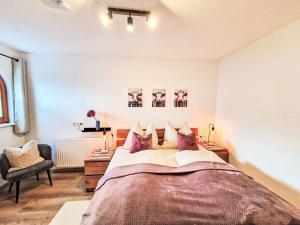 a bedroom with a large bed and a chair at Apartment August by Interhome in Schlitters
