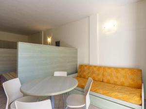 a dining room with a table and white chairs at Studio Borgoverde-12 by Interhome in Imperia