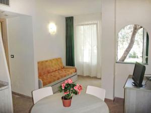 a living room with a table and a couch at Studio Borgoverde-12 by Interhome in Imperia +24 photos