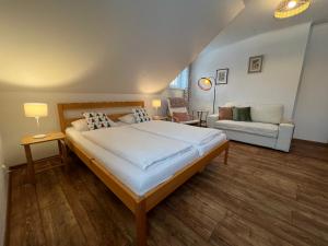a bedroom with a large bed and a couch at Apartment Brusinka in Kašperské Hory