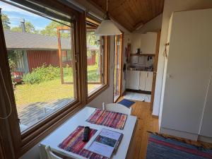a dining room with a table and a window at Liten stuga med havsutsikt in VBY
